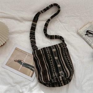 Flat lay of plush shoulder bag with geometric tribal pattern and soft furry texture