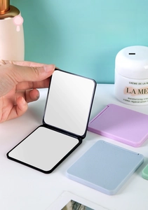 Detail of portable folding makeup mirror featuring dual-sided glass and matte texture