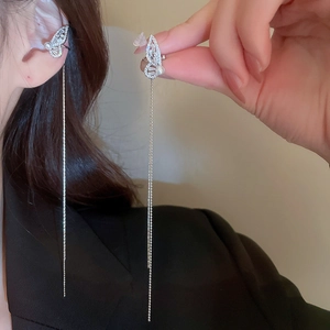 Detail of silver butterfly tassel earrings with sparkling zircons and a white pearl accent