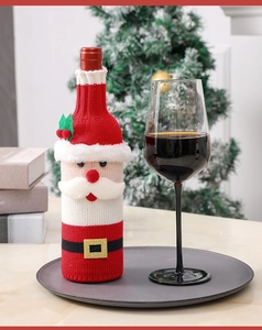 Close-up of knitted Santa wine bottle cover with plush details in a cozy Christmas setting