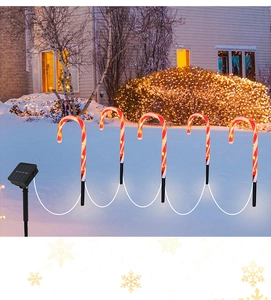 Solar powered Christmas candy cane path lights with red and white stripes on snow