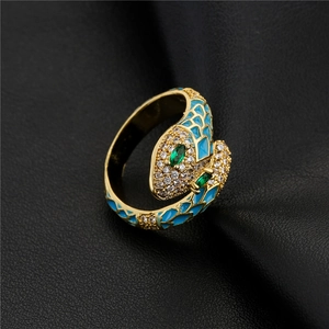 Golden snake ring with blue enamel and emerald zircon eyes on black leather