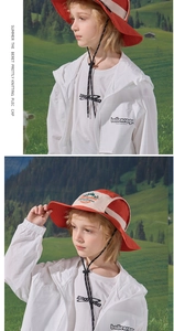 Detail of red and beige children's sun hat with wide brim and adjustable wind rope