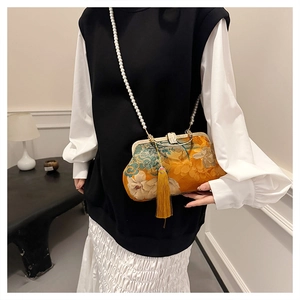 Detail of yellow floral silk clasp bag with elegant pearl chain and long tassel decoration