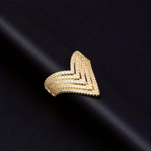 Macro shot of gold layered V-shaped ring with pavé cubic zirconia on black stand