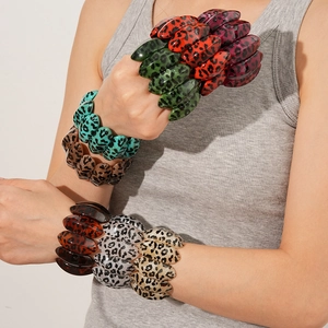 Detail shot of multi-colored leopard print acrylic elastic bracelets stacked on a wrist