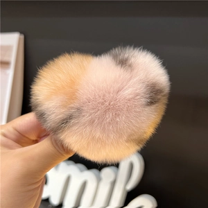 Macro detail of the plush heart-shaped hair clip showing soft gradient faux rabbit fur