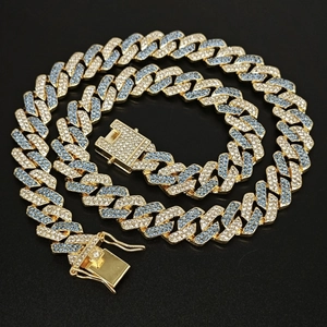 Detail of 14mm Cuban link necklace featuring blue and clear pavé stones on gold plating
