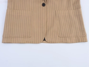 Detail of khaki striped linen blazer featuring large patch pockets and button closure