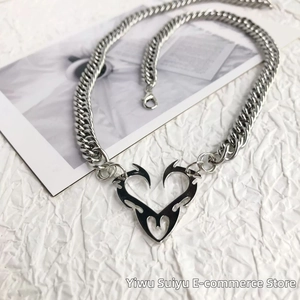 Macro detail of silver tribal heart pendant with thick Cuban link chain on white background