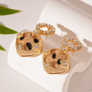 Détail de boucles d'oreilles rétro à imprimé léopard floqué et strass sur support