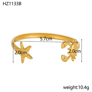 Detail view of gold stainless steel bangle with starfish and crab charms, size 5.7cm