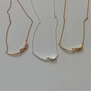 Detailed view of three 925 sterling silver bow necklaces in gold, silver and rose gold