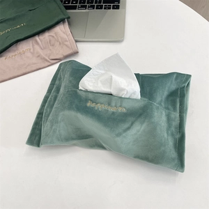 Detail of velvet tissue bags in mint green and pink with golden Happiness embroidery