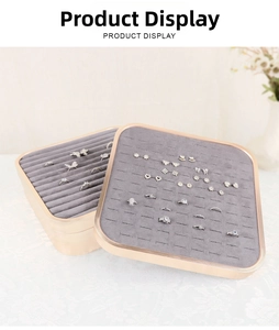 Detail of jewelry display tray with gold metal frame, grey velvet lining and ring slots