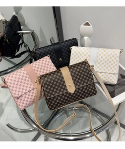 Detail of crossbody mini square bags with geometric patterns and magnetic gold buckles