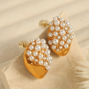 18K gold plated stainless steel stud earrings with pave pearls on a stone background