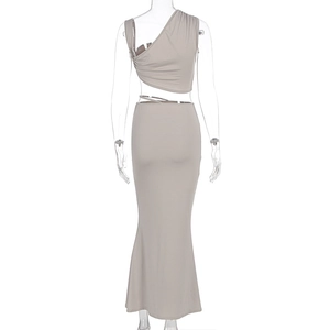 Detail of ruched two-piece set featuring asymmetrical top and bodycon maxi skirt