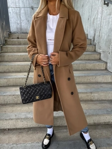 Outdoor shot of camel long wool coat featuring classic notched lapels and double-breasted buttons