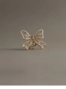 Detail of a French style golden butterfly hair claw clip with inlaid pearls