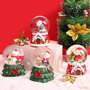 Christmas musical snow globes with Santa and reindeer on festive red and green bases