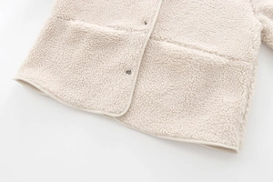 Detailed macro view of cream teddy fleece texture and reinforced pocket stitching