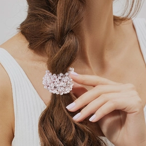 Elegant white faux pearl hair scrunchie shown on a braided ponytail for women