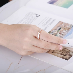 Rose gold stainless steel ring with shell inlay and cubic zirconia on model's finger