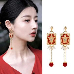 Detail view and model wearing vintage resin pearl tassel earrings with floral accents