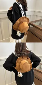 Detail of western cowboy hat backpack featuring faux suede and cow print straps with plush charm