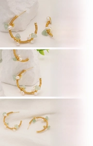 Detail of handmade wire-wrapped earring with natural freshwater pearl and green stone