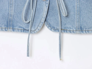 Détail de l'ourlet en jean bleu clair avec des coutures précises et des cordons serrés
