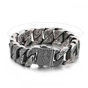 Detail view of vintage stainless steel bracelet with ornate engraved patterns and snap buckle