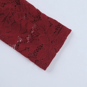 Macro shot of dark red lace cuff details showcasing intricate floral hollow patterns