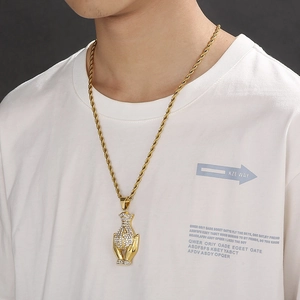Detail of hip hop gold hands holding money bag pendant with diamonds on rope chain