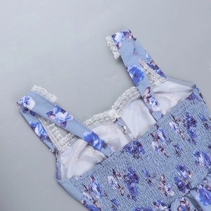 Detail des blau-violetten Blumenkleids mit weißen Spitzen-Trägern und Raffung