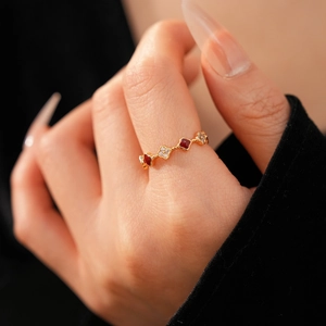 Macro detail of 18k gold plated four-leaf clover ring with red inlay and cubic zirconia