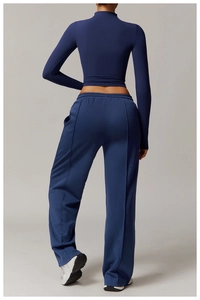 Rear view of tight high-neck long sleeve top and wide-leg yoga pants in navy blue