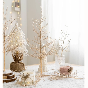 Winter festive scene with golden icy branches, white knit trees and decorative candles
