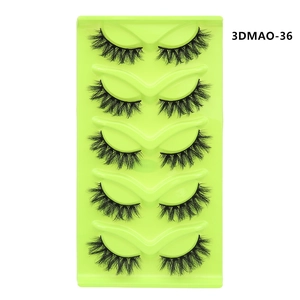 Detail of 5 pairs of thick cat-eye false eyelashes with crossed patterns on a green tray