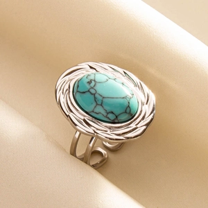Close-up of bohemian adjustable silver ring with oval turquoise stone on silk