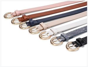 Close-up of thin leather belts in seven colors with rhinestone-encrusted gold buckles