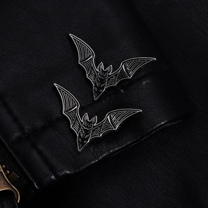 Gothic bat pins in black metal with silver lines on a black leather jacket lapel