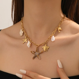 Gold chain necklace featuring starfish turtle and shell pendants on a model
