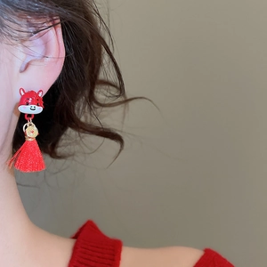 Detail of red cartoon animal earrings with gold coins and long silk tassels
