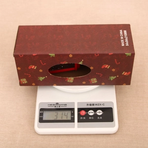 Detailed view of festive red Christmas lantern packaging box showing 314g weight on a scale