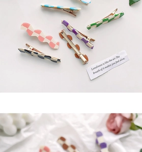 Detail view of wavy checkered hair clips in candy colors including pink and purple