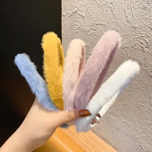 Five colorful plush headbands in pastel tones held together on a textured background