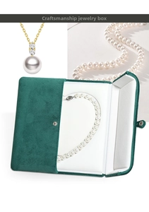 Detail showing emerald green velvet jewelry box with snap closure and white pearl necklace