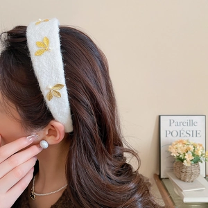Detail of white flocked leaf headband with pearls on an elegant French style headpiece